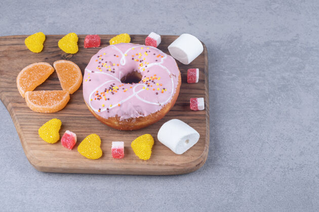 甜点棉花糖 蜜饯和甜甜圈放在大理石表面的木板上美味棉花糖果酱