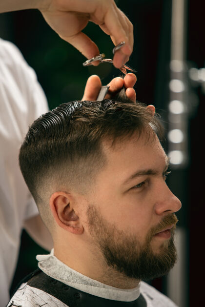 剃刀特写理发师 发型师给男生 年轻人做发型专业职业 男性美容理念客户的头发 胡子 胡须的护理柔和的颜色和焦点 复古毛巾剪理发师