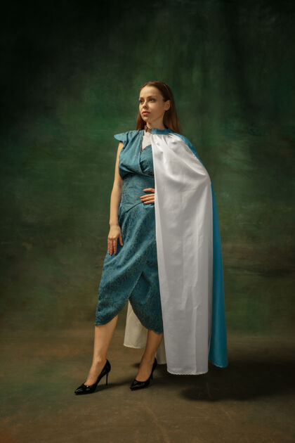 民间优雅的姿势在黑暗的背景下 中世纪年轻女子身着蓝色复古服装的肖像作为公爵夫人 皇室成员的女性模特时代 现代 时尚 美丽的比较概念肖像城堡人
