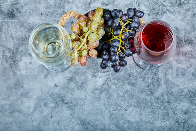 食物一束白葡萄和黑葡萄 两杯白葡萄酒和红葡萄酒 蓝色背景高品质照片葡萄新鲜葡萄酒