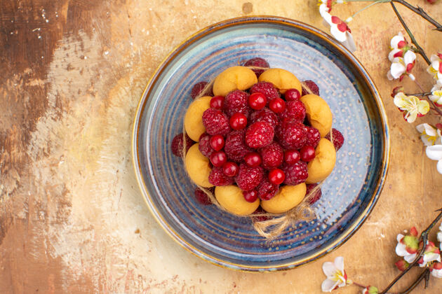 蔓越莓上图：混色桌上新鲜出炉的带水果和鲜花的软蛋糕健康可食用水果饮食