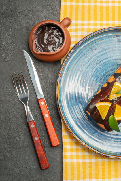 餐具美味的蛋糕用橙子和巧克力装饰 用叉子和刀子垂直观看厨具刀厨具