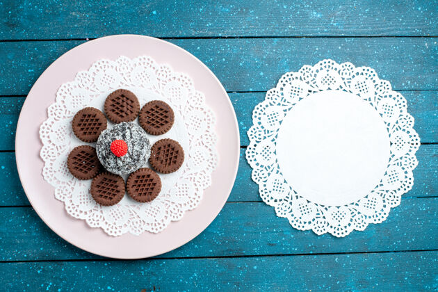 陶瓷器皿俯瞰美味的巧克力饼干与巧克力蛋糕上的蓝色乡村办公桌饼干茶饼干甜蛋糕糖容器瓷器顶部