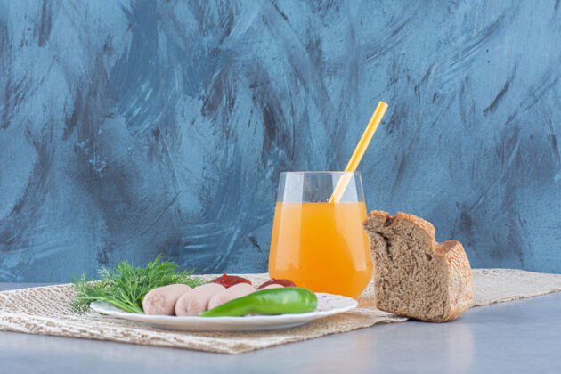 绿色简单的英式早餐香肠和橙汁配面包自然新鲜香料