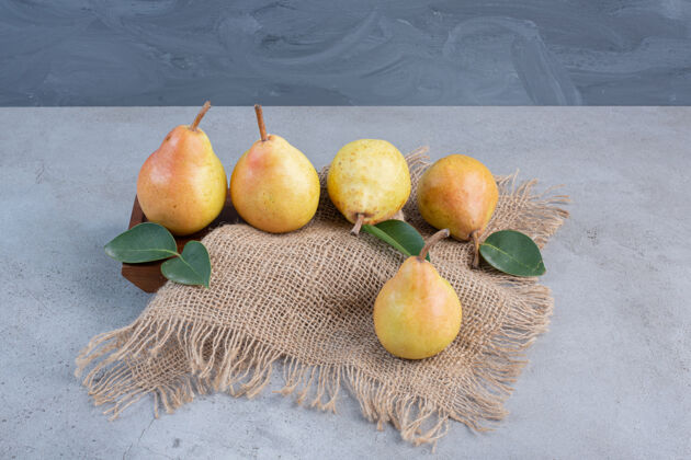 配料梨子放在一块木板上 上面覆盖着一块布 背景是大理石营养布块新鲜