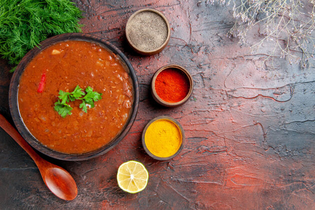 香料上图：棕色碗中的经典番茄汤和混色桌上的不同香料香草食物姜黄