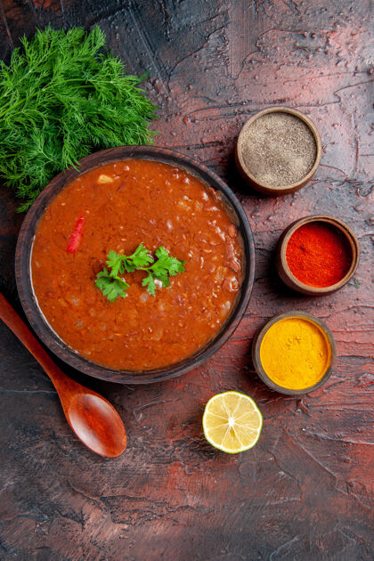 混合棕色碗中的经典番茄汤和混色桌上的不同香料的水平视图香料晚餐水平