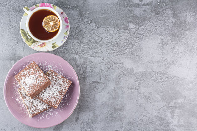 甜点自制饼干的顶视图和一杯香茶在灰色上温暖生活配料