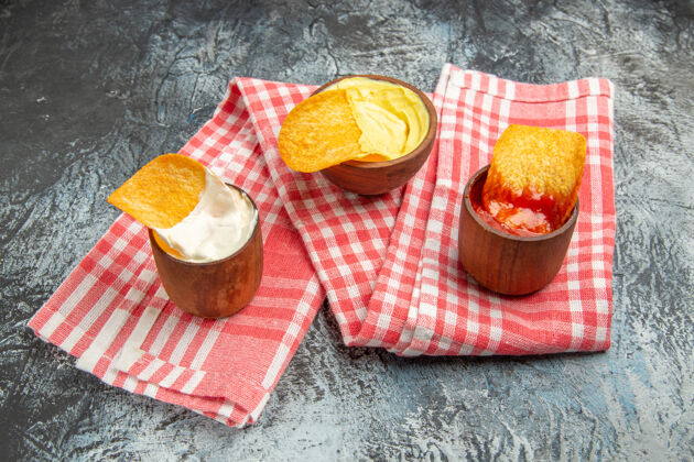 营养自制脆皮薯片番茄酱蛋黄酱放在灰色桌子上的红毛巾上盘子小吃薯片