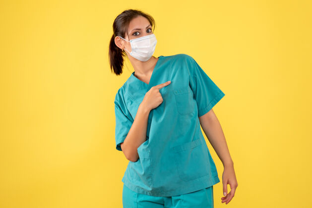 衬衫前视图黄色背景上穿着医用衬衫和面罩的女医生人流行病医疗