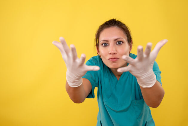 视图前视图黄色背景上戴着医用手套的女医生男生健康肖像