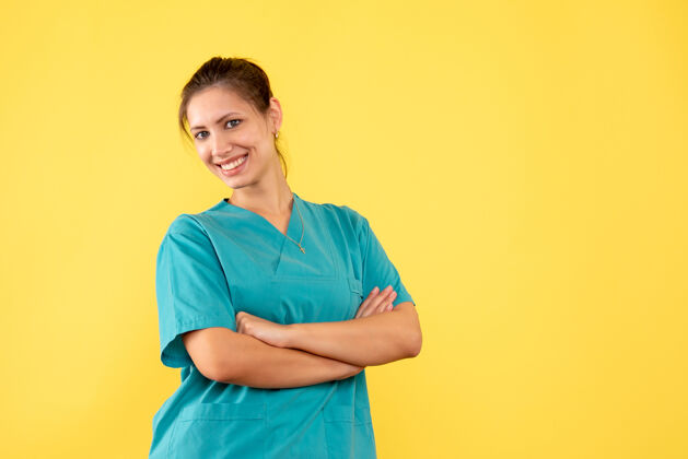 健康正面图黄色背景上穿着医疗衬衫微笑的女医生衬衫微笑成人
