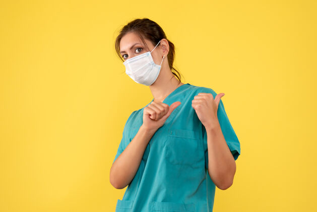 面具前视图黄色背景上穿着医用衬衫和面罩的女医生病毒衬衫正面