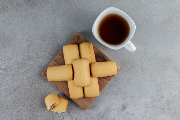 可口一杯白茶 放在石头上的木板上 里面放着甜的新鲜饼干板美味糕点