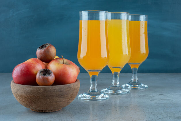 食物一个木制的苹果碗和一杯橙汁木头苹果水果