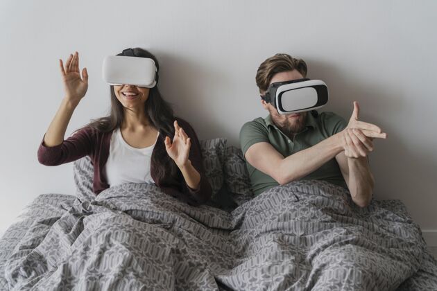 虚拟现实眼镜男人和女人在家玩虚拟现实耳机玩得很开心虚拟现实男人房子