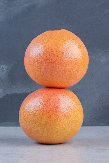 特写两个新鲜的柚子 灰色背景柑橘葡萄柚一半