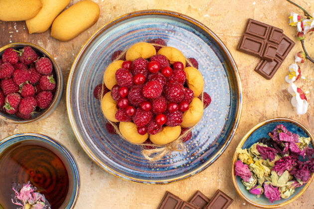 饮食上图：混合色桌上的热凉茶软蛋糕和水果巧克力条水果草药热的