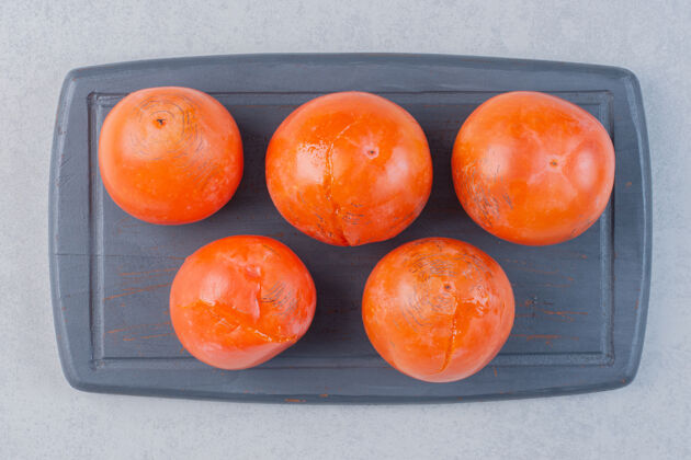 营养成熟的桔子柿子新鲜的柿子放在木板上抗氧化剂水果亚洲