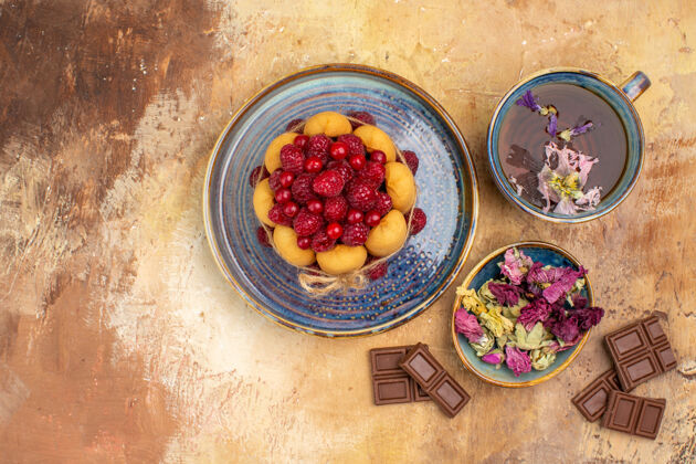 软蛋糕一杯热花草茶的水平视图软蛋糕与水果和鲜花巧克力条浆果可食用水果新鲜