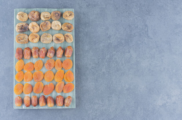 盘子杏干放在木板上 大理石背景上美味干果蛋白质