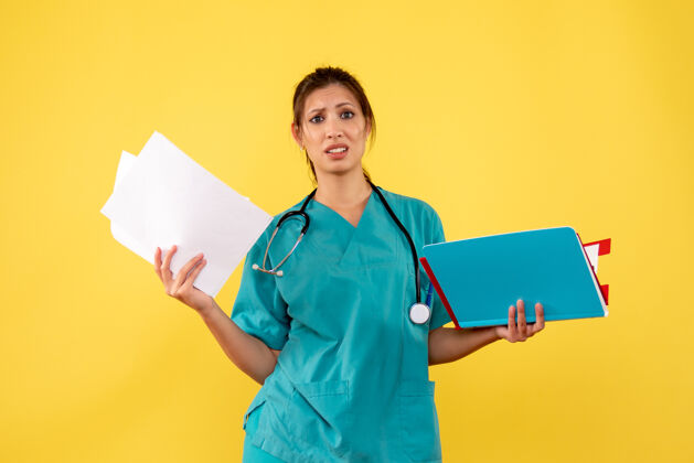 衬衫正面图黄色背景下穿着医用衬衫的女医生拿着分析健康医疗人