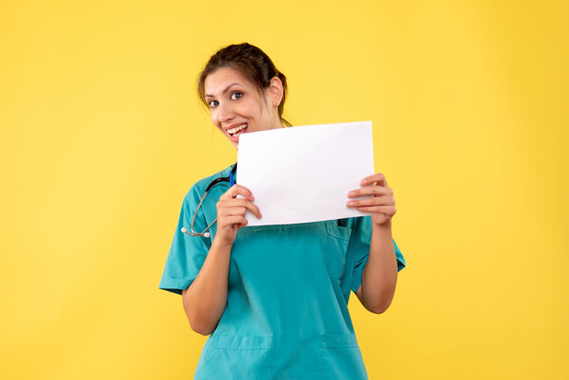 肖像正面图女医生穿着医用衬衫拿着纸黄色办公桌上的病毒分析彩色医院保健药纸黄色病毒