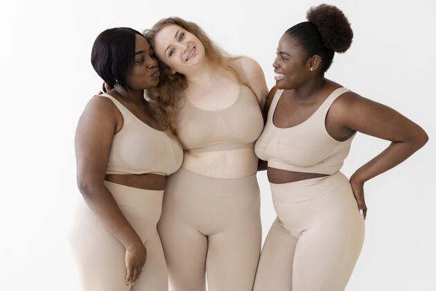 紧身衣三个自信快乐的女人穿着塑身衣摆姿势社会运动女人女性授权