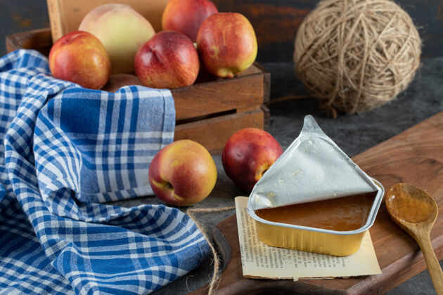 压缩桃子和木勺放在木板上的甜果酱糖水果成熟