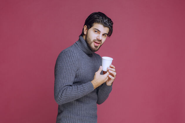 人男人手里拿着一次性咖啡杯 感觉很积极成人温暖工人