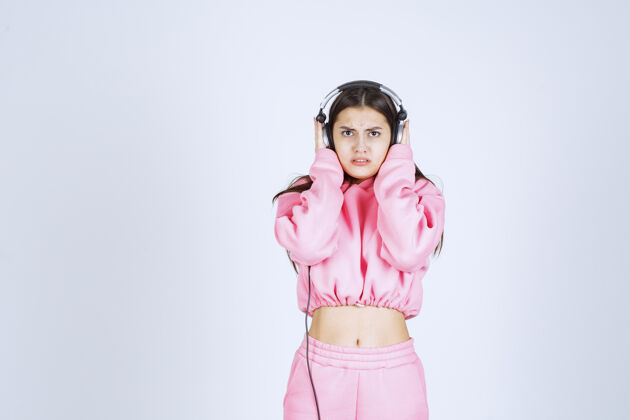 娱乐穿着粉色睡衣的女孩在听耳机 不喜欢音乐人年轻服装