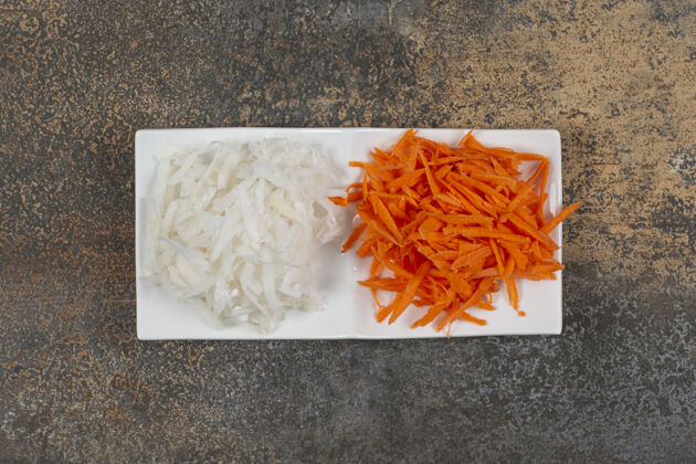 剁碎白菜丝和胡椒粉放在白盘子里切有机卷心菜