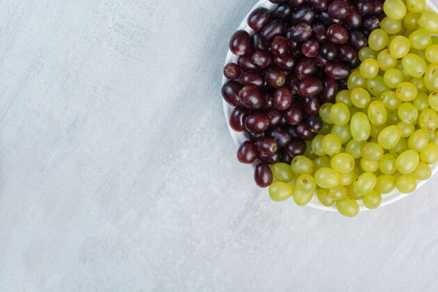 水果紫色和绿色的葡萄放在白色的盘子里美味有机新鲜