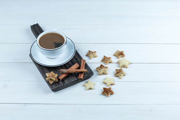 小吃高角度观看一杯咖啡 肉桂切肉板与星星饼干在白色木板背景水平薯条桌子切割