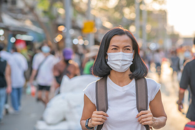 病毒街上戴着面具的女孩旅游面具流行病