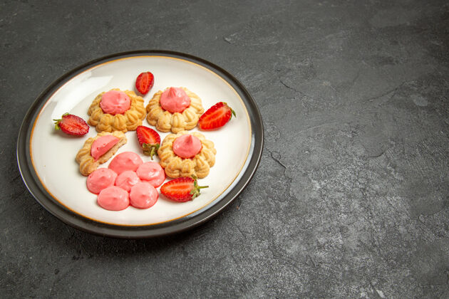 饼干前视图美味的小饼干与粉红色奶油盘子内的灰色空间蛋糕饼干早餐