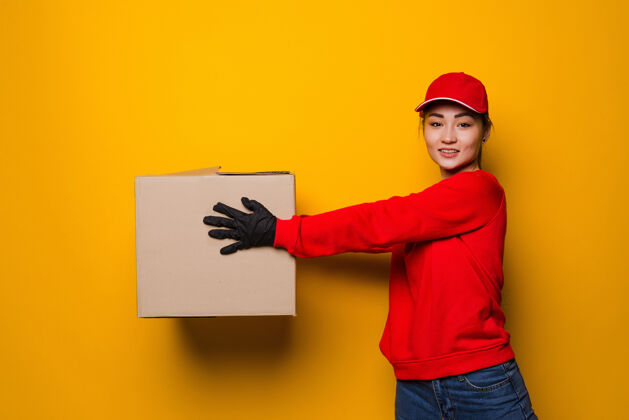 病毒年轻的亚洲女送货员拿着黄色的箱子流感喜悦健康