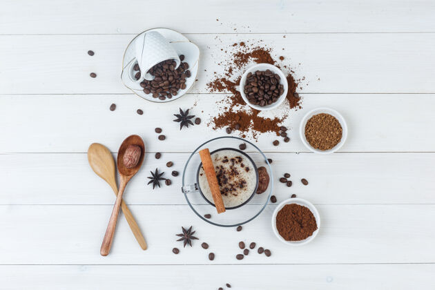 芳香顶视图咖啡杯 咖啡豆 磨碎的咖啡 香料 日期 木制背景上的木制勺子枣杯子食物