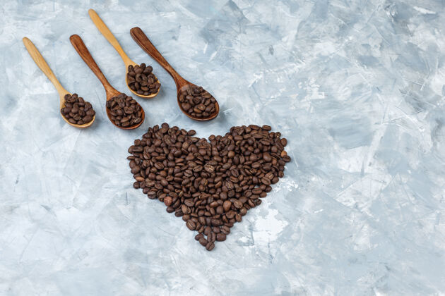 摩卡咖啡一些咖啡豆放在灰色灰泥背景的木勺里 平放着卡布奇诺新鲜的阿拉伯语