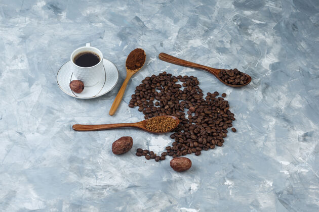 高角度查看速溶咖啡 咖啡粉 咖啡豆在木制勺子与咖啡杯 饼干浅蓝色大理石背景水平浓缩咖啡咖啡馆热的