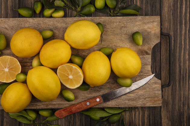 柠檬健康水果的俯视图 如金盏花和柠檬 放在木制厨房板上 刀放在木制表面人美味农业