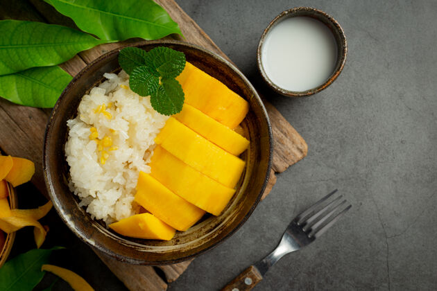 热带新鲜成熟的芒果和糯米 在黑暗的表面涂上椰子奶奶油芒果顶级