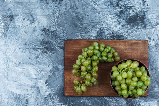 秋天把一碗葡萄平放在深蓝色大理石背景的砧板上水平自然饮食浆果