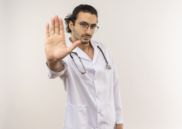 停止年轻的男医生戴着眼镜 穿着白袍 带着听诊器眼镜医生听诊器