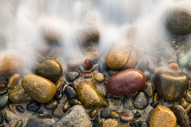 海岸覆盖着海泡石的鹅卵石特写镜头海洋石头卵石