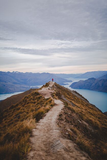 云景一个人站在新西兰罗伊斯峰步行路尽头的垂直高角度镜头日落岩石冒险