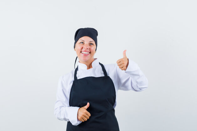 制服身着制服的女厨师 围裙上竖起大拇指 看上去很高兴 正面照时尚优雅成人