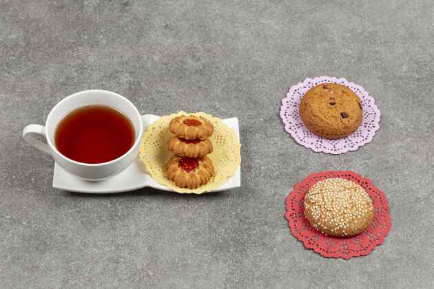 杯子一杯茶和各种饼干放在大理石表面甜点果酱美味