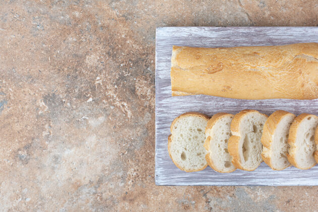 面包皮新鲜的法式面包放在木板上脆的切的一半