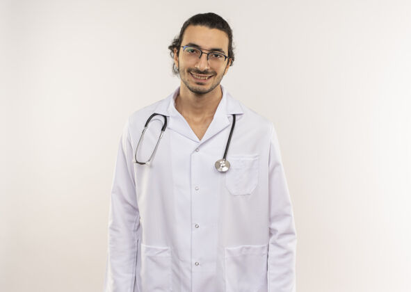 医生微笑的年轻男医生 戴着眼镜 身穿白色长袍 听诊器放在隔离的白色墙上 留有复印空间光学男性年轻